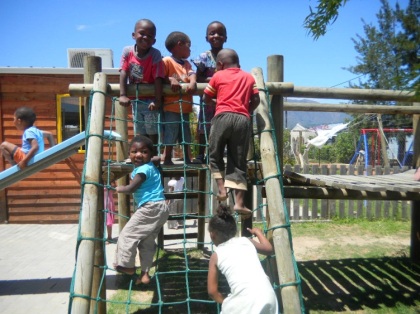 7 Active orphans living with HIV climbing on playground gym set in South Africa.  Some of the orphans are elligible for adoption